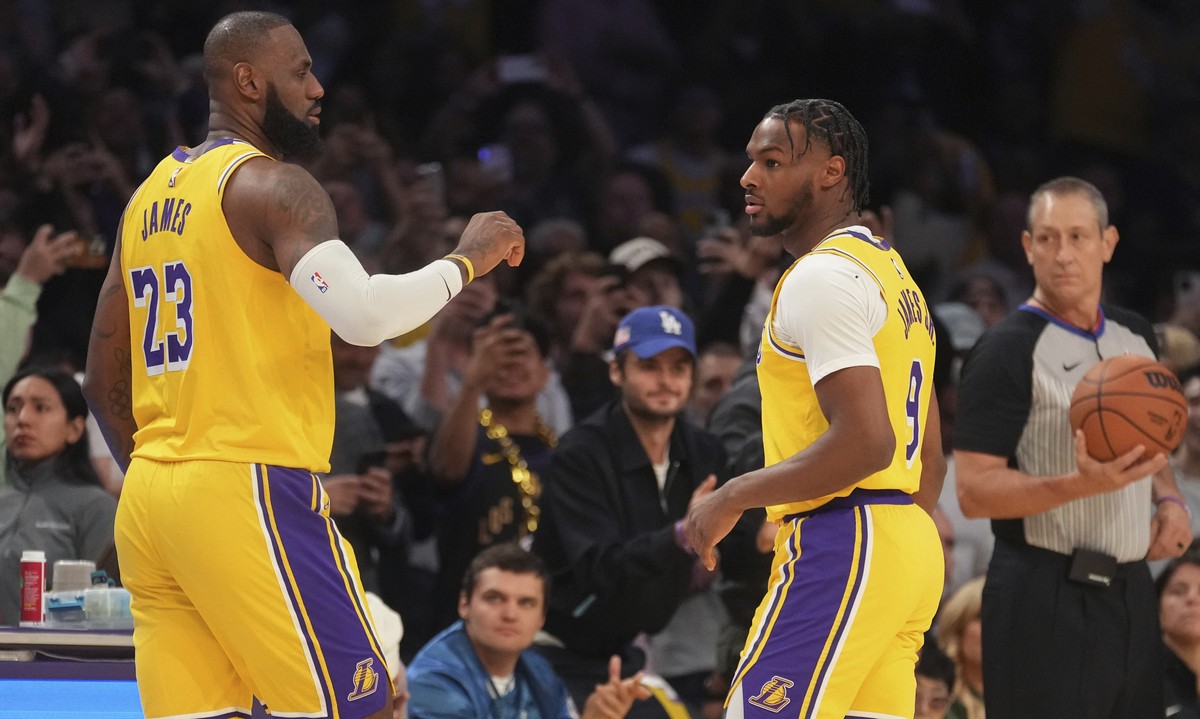 Los Angeles Lakers forward LeBron James (23) and guard Bronny James (9) stand on the court during the first half of an NBA basketball game against the Minnesota Timberwolves, Tuesday, Oct. 22, 2024, i ...