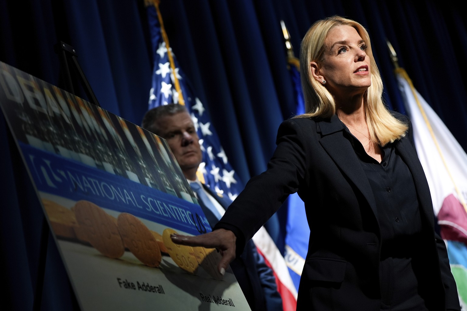 Attorney General Pam Bondi points to a graphic while speaking at a news conference at the Drug Enforcement Administration, Tuesday, July 15, 2025, in Arlington, Va. (AP Photo/Julia Demaree Nikhinson)
 ...