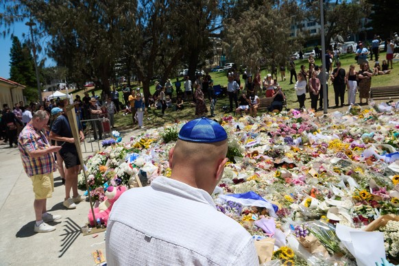 epa12597504 Members of the public lay flowers at a floral tribute honouring victims of a stabbing attack at Bondi Beach in Sydney, Australia, 17 December 2025. Australia is in mourning following an at ...