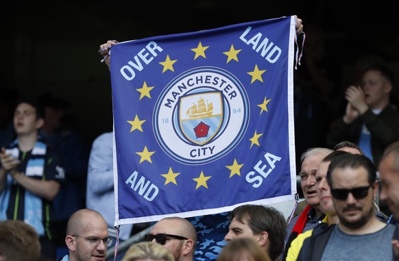 A Manchester City fan holds up a banner on the stands before the start of the English Premier League soccer match between Brighton and Manchester City at the AMEX Stadium in Brighton, England, Sunday, ...