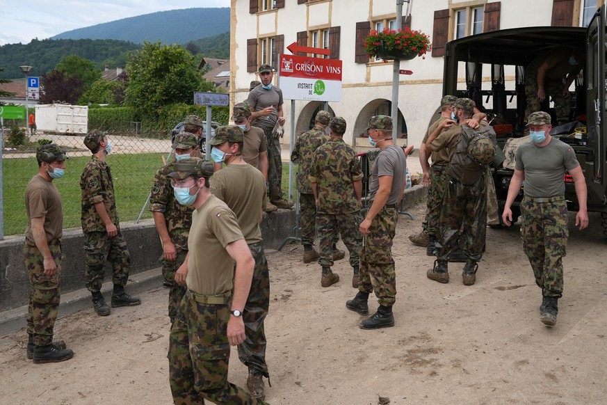 Einsatzkraefte der Schweizer Armee helfen am Sonntag, 27. Juni 2021 bei den Aufraeumarbeiten in Cressier, NE, wo auf der Nacht zu 23. Juni ein Unwetter schwere Ueberschwemmungen und Schaeden verursach ...