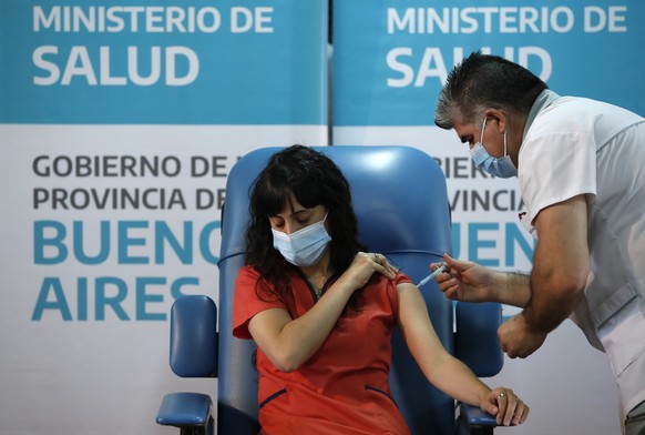 Nurse Gustavo Rodriguez gives Dr. Estefania Zevrnja a shot of Russia&#039;s Sputnik V vaccine for COVID-19 at Dr. Pedro Fiorito Hospital in Avellaneda, Argentina, Tuesday, Dec. 29, 2020. (AP Photo/Nat ...