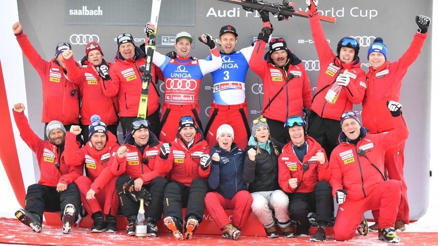 ABD0126_20200213 - SAALBACH-HINTERGLEMM - ÖSTERREICH: (v.l.) Beat Feuz (2.Platz/SUI) und Mauro Caviezel (3.Platz/SUI) mit Team am Podium der Weltcup Abfahrt der Herren am Donnerstag, 13. Februar 2020, ...