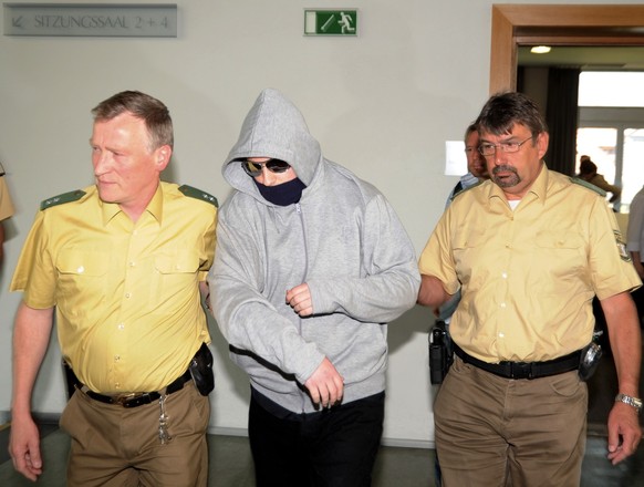 Der angeklagte Amoklaeufer Georg R., Mitte, wird am Donnerstag, 29. April 2010, aus dem Landgericht Ansbach gefuehrt. Der angehende Abiturient war 17. September 2009 mit einem Beil, Messern und Brands ...