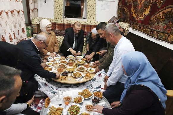 In this Tuesday, May 22, 2018 photo, Turkey&#039;s President Recep Tayyip Erdogan, center, and his wife Emine Erdogan, centre left, join Huseyin Cahit Sargin&#039;s family during an Iftar, the evening ...