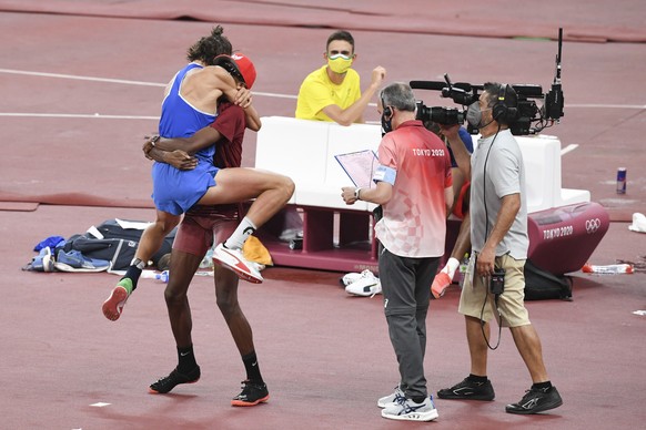 epa09385729 Gianmarco Tamberi of Italy (L) and Mutaz Essa Barshim of Qatar (2-L) celebrate as they share the first place and gold medal in the Men&#039;s High Jump Final during the Athletics events of ...