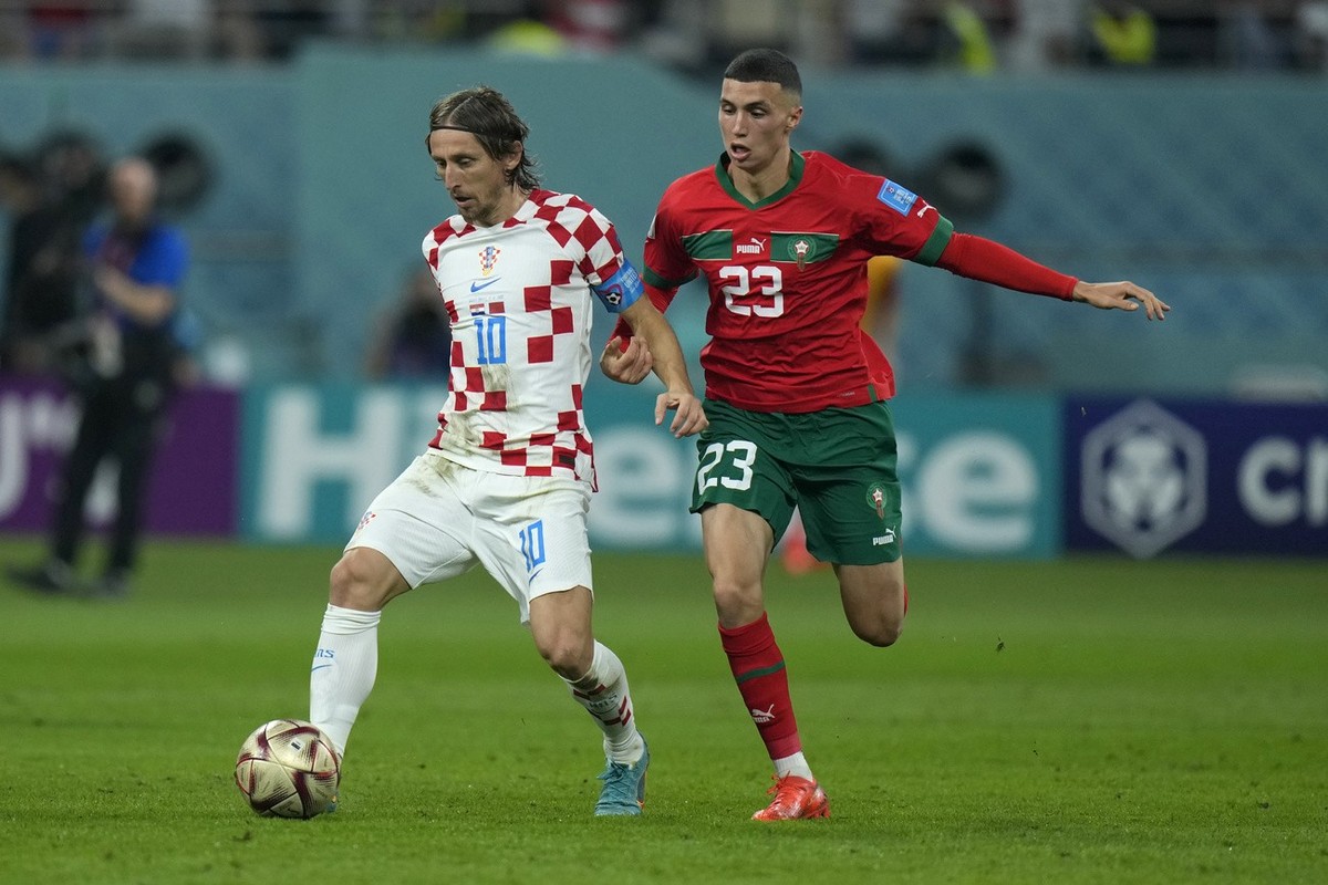Croatia's Luka Modric, left, and Morocco's Bilal El Khannous vie for the ball during the World Cup third-place playoff soccer match between Croatia and Morocco at Khalifa International Stadi ...