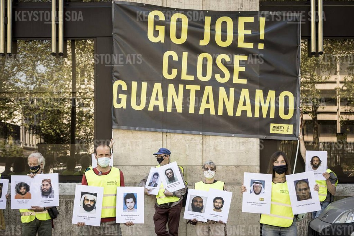 Des manifestants détiennent des photos de personnes détenues dans le centre de détention américain de Guantanamo Bay, à Cuba, lors d'une manifestation lors d'un sommet de l'OTAN à Bruxe ...
