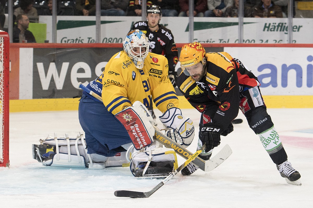 Davos Goalie Gilles Senn, links, und Berns Top Scorer Andrew Ebbett, rechts, kaempfen um den Puck, beim Eishockey Meisterschaftsspiel der National League zwischen den SC Bern und dem HC Davos, am Frei ...