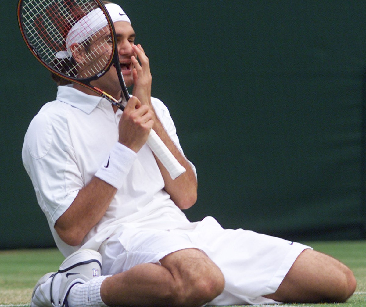 Roger Federer of Switzerland falls to his knees, as he defeats defending champion Pete Sampras in their men's singles, fourth round match on the Centre Court at Wimbledon, Monday July 2, 2001. (K ...