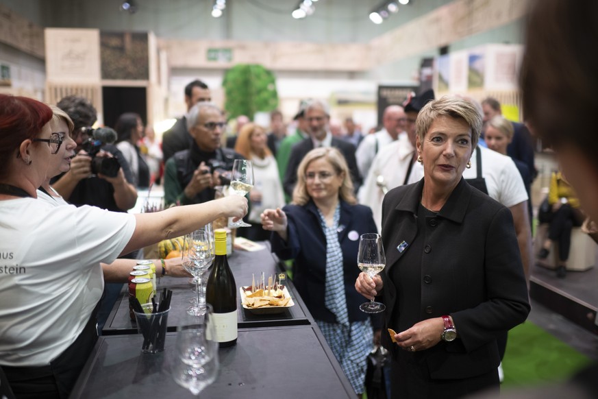 Bundesraetin Karin Keller-Sutter mit einem Glas Wein, im Hintergrund die St. Galler Stadtpraesidentin Maria Pappa, bei der Eroeffnung der 80. OLMA Schweizer Messe fuer Landwirtschaft und Ernaehrung, a ...