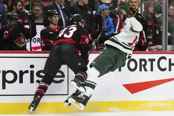 Ottawa Senators defenseman Tyler Kleven (43) checks Minnesota Wild forward Yakov Trenin (13) in front of the Senators bench during first-period NHL hockey game action in Ottawa, Ontario, Saturday, Feb ...
