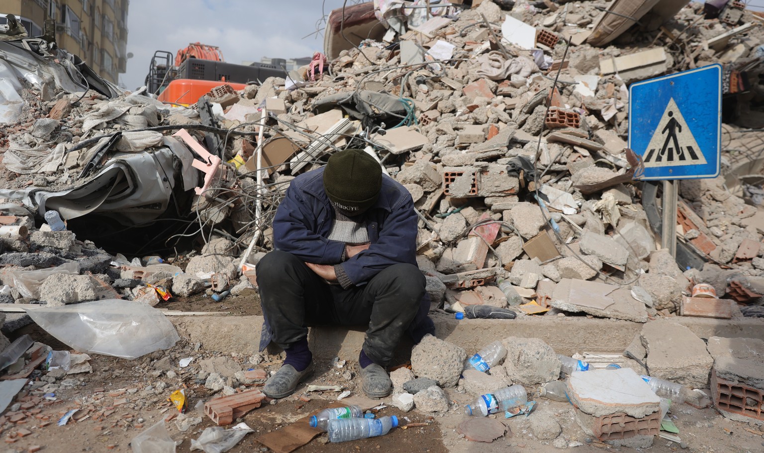 epa10458920 A man reacts at the site of a collapsed building following a powerful earthquake in the city of Kahramanmaras, Turkey, 10 February 2023. More than 21,000 people have died and thousands mor ...