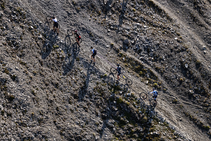 epa09423116 Riders push their bike on the &quot;Pas de Lona&quot; during the 31st Swiss Mountain Bike Marathon &quot;Grand Raid&quot; from Verbier to Grimentz, Southwestern Switzerland, 21 August, 202 ...