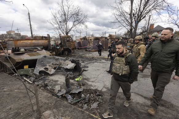 epa09870359 A handout photo made available by the Ukrainian Presidential Press Service shows Ukrainian President Volodymyr Zelensky (C) walking by a street with damaged Russian machinery in the recapt ...