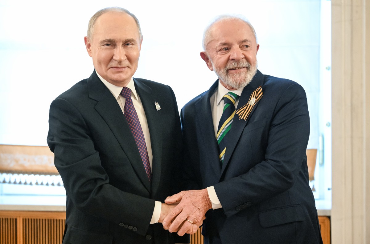 epa12084965 A handout photo made available by Photo host Agency RIA Novosti shows President of Russia Vladimir Putin (L) welcoming President of Brazil Ignacio Lula da Silva before a gala concert held  ...
