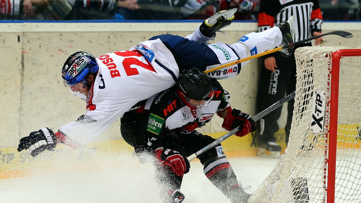 COLOGNE, GERMANY - DECEMBER 03: Philip Gogulla (C) of Koelner Haie checks Florian Busch of Eisbaeren Berlin during the DEL Ice Hockey match between Koelner Haie and Eisbaeren Berlin at Lanxess Arena o ...