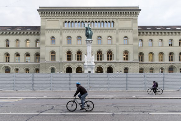 Passanten fahren vor einem Schutzzaun vor dem Bundeshaus West vorbei, am Freitag, 6. Oktober 2017 in Bern. Eine unbewilligte &quot;antifaschistische Demonstra­tion&quot; wurde auf Freitagabend angekue ...