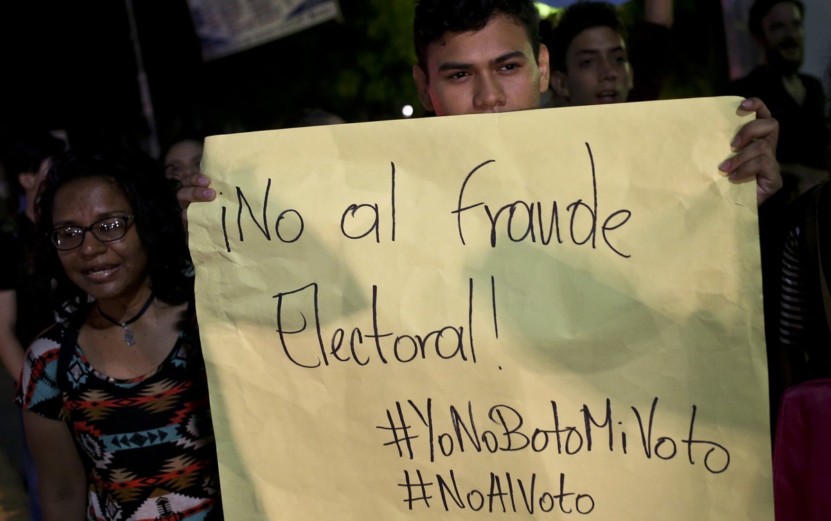 A university student shows a banner in spanish "No Electoral Fraud" during a protest against Nicaragua's President Daniel Ortega and presidential election process in front of the Centra ...