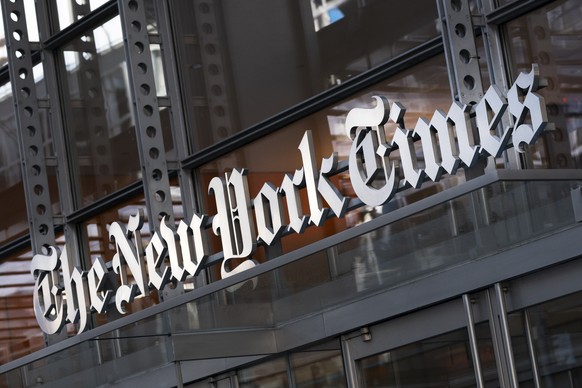FILE - A sign for The New York Times hangs above the entrance to its building, Thursday, May 6, 2021 in New York. On Monday, Jan. 31, 2022, the Times announced it has bought Wordle, the free online wo ...