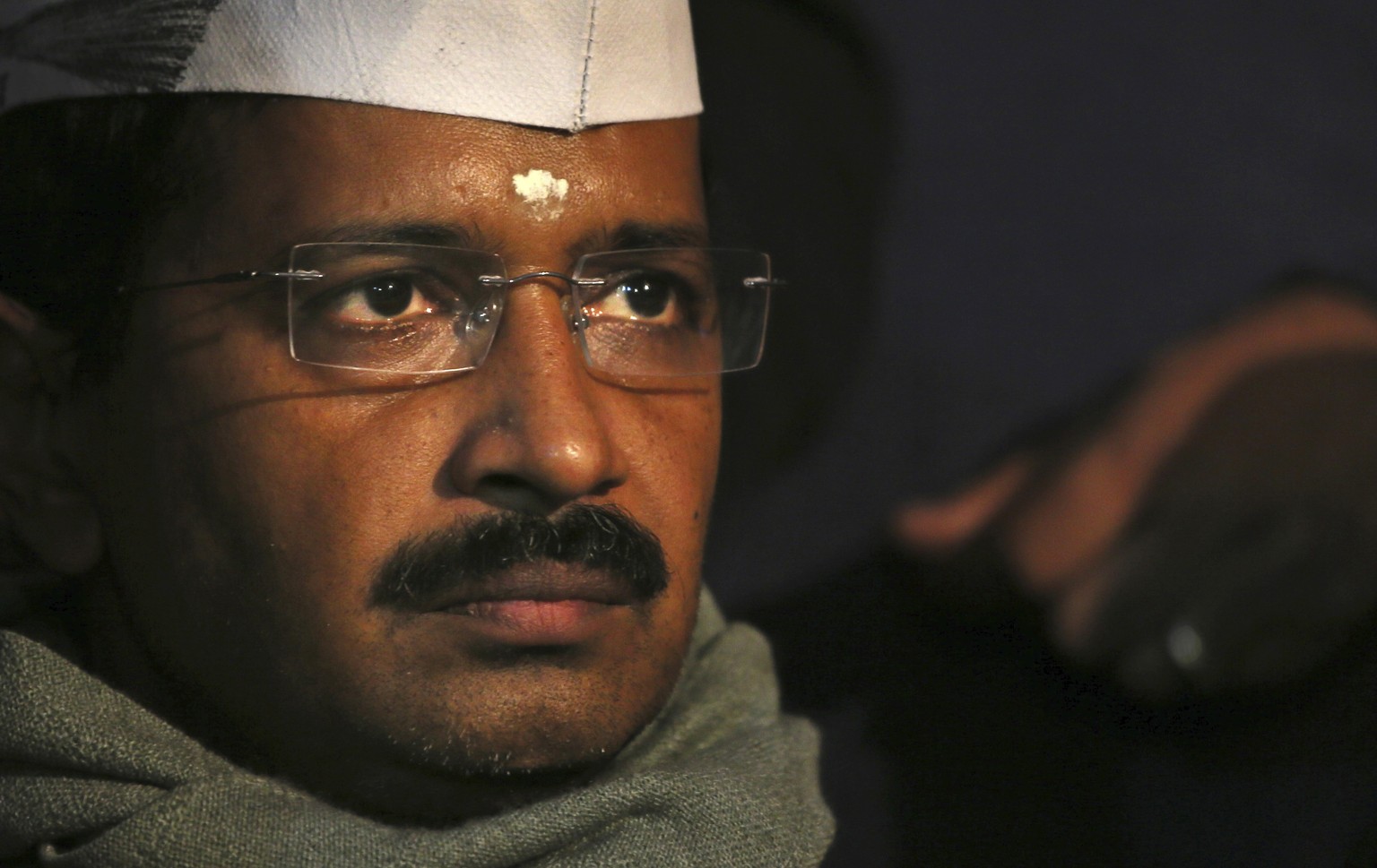 Aam Aadmi Party, or Common Man&#039;s Party, leader Arvind Kejriwal listens to a speaker during a public meeting in New Delhi, India, Dec. 27, 2013. The anti-corruption crusader was arrested on Thursd ...
