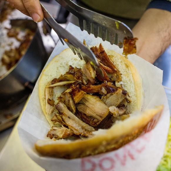 epa06365649 An employee fills doener meat into a kebab bread in Vienna, Austria, 03 December 2017. A change in EU regulations could possible cause the doener kebabs being banned across the European Un ...