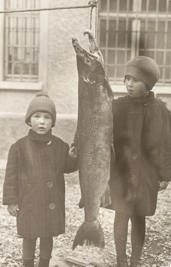 Zwei Kinder mit einem Lachs bei Augst, undatierte Fotografie. Bis in die 1920er-Jahre wurden in Basel zahlreiche Lachse gefangen.