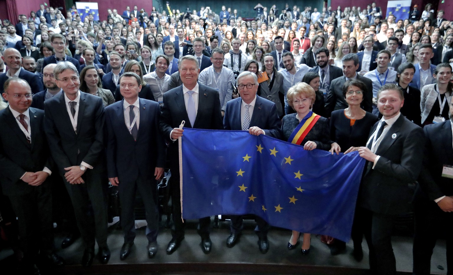 epa07556300 EU Commission President Jean-Claude Juncker (C-R) holds the EU flag while posing for a family photo at the &#039;Young Citizens&#039; Dialogue&#039; in Sibiu with the President of Romania, ...