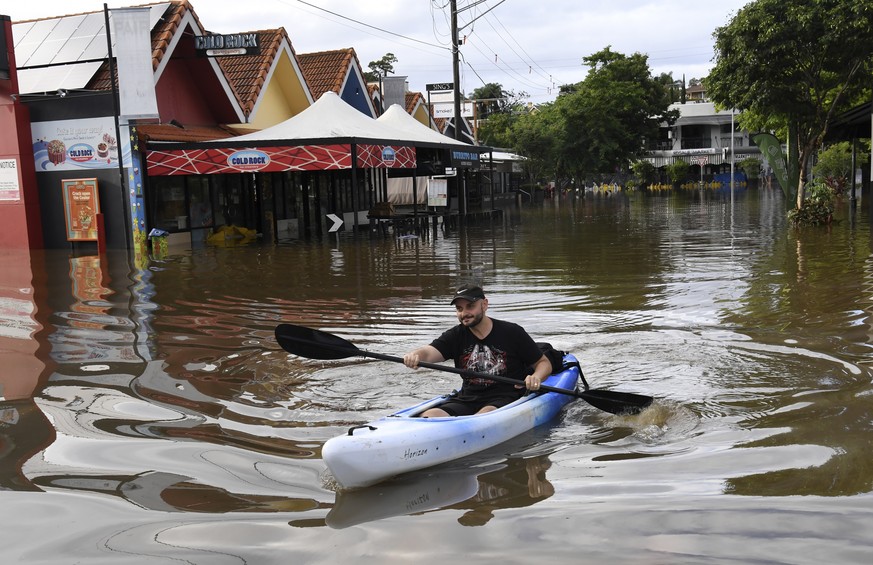 A man paddles a kayak on a flooded street in Brisbane, Australia, Monday, Feb. 28, 2022. Heavy rain is bringing record flooding to some east coast areas and claimed seven lives while the flooding in B ...
