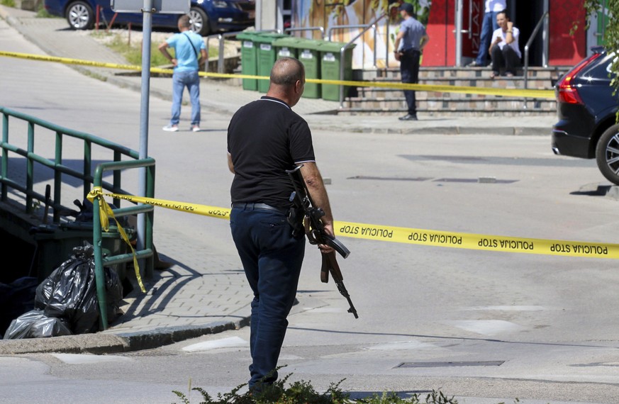 A plain-clothes police officer holds a rifle as they launch a major chase for a man who claimed to have shot and killed his wife while broadcasting it live on Instagram, in the small town of Gradacac, ...
