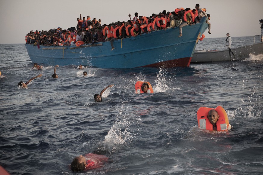 JAHRESRUECKBLICK 2016 - AUGUST - Migrants, most of them from Eritrea, jump into the water from a crowded wooden boat as they are helped by members of an NGO during a rescue operation at the Mediterran ...