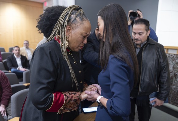 Wichita, Kan., mayor Lily Wu, right, prays with Rev. Pamela Hughes before a prayer vigil in Wichita, Kan., on Thursday, Jan. 30, 2025, for those affected by the crash of American Airlines flight 5342  ...