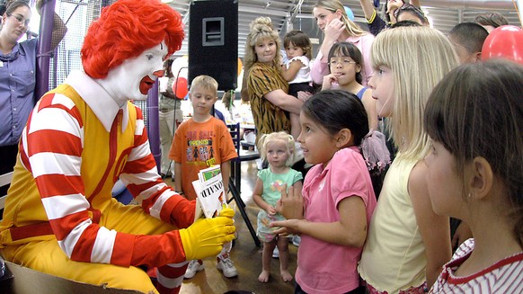 FILE - In this file photo taken May 18, 2006, Ronald McDonald visits with children at a McDonald's Restaurant in Roswell, N.M. Taco Bell is using real-life people named Ronald McDonald in a marketing  ...
