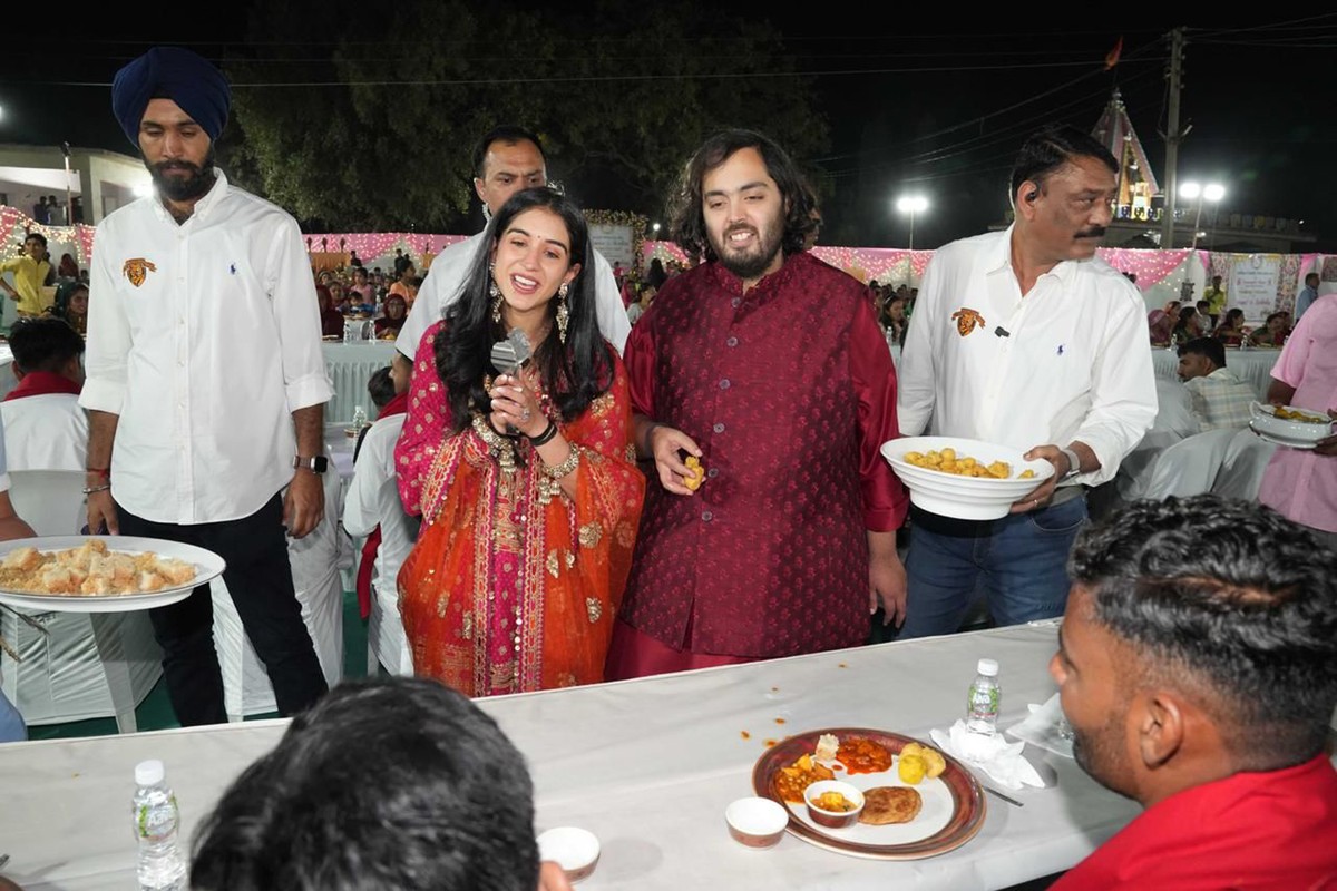 This photograph released by the Reliance group shows Reliance Industries Chairman Mukesh Ambani's son and groom Anant Ambani, center right, and bride Radhika Merchant, center left interacting wit ...