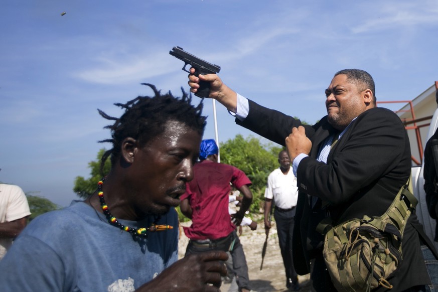 Ruling party Senator Ralph Fethiere fires his gun outside Parliament as he arrives for a vote on the ratification of Fritz William Michel&#039;s nomination as prime minister in Port-au-Prince, Haiti,  ...