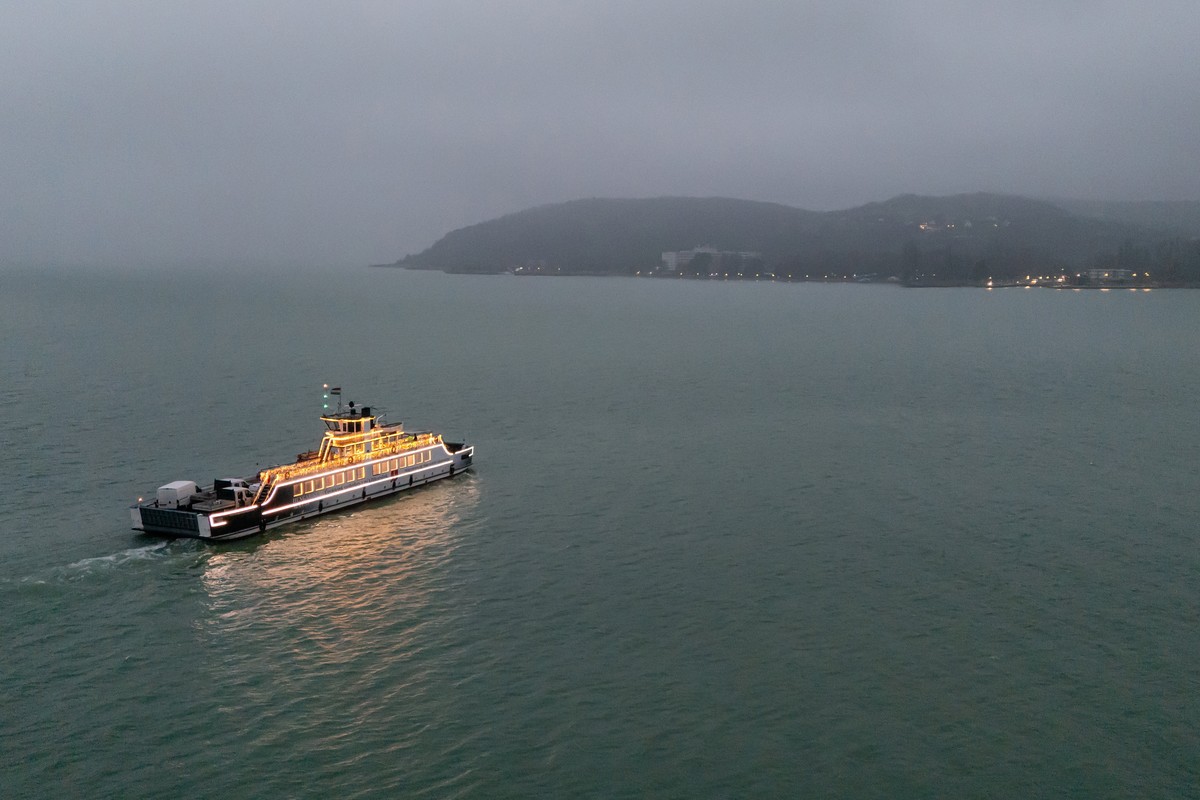 epa12566398 An image taken with a drone shows the illuminated ferry on Lake Balaton at Szantod, Hungary, 03 December 2025. The 'Light Ferry' is operating from the last weekend of November un ...