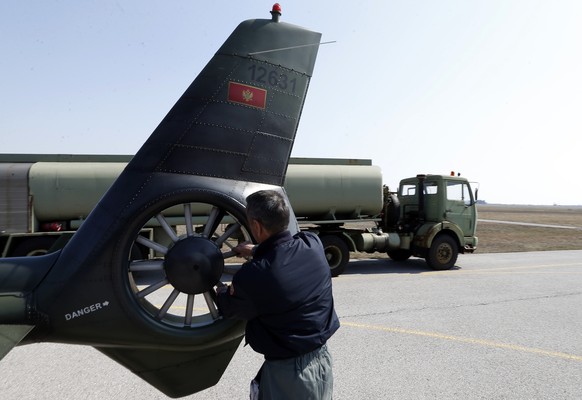 A crew member prepares a Montenegrin army helicopter at Golubovci airport, near Podgorica, Montenegro, Wednesday, March 15, 2017. Aspiring NATO member Montenegro is hardly a formidable military force, ...