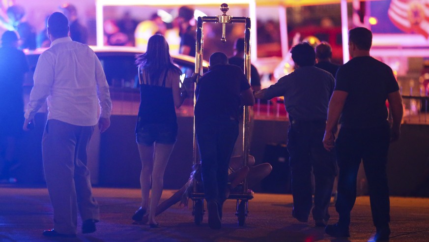 A wounded woman is moved outside the Tropicana during an active shooter situation on the Las Vegas Strip in Las Vegas Sunday, Oct. 1, 2017. Multiple victims were being transported to hospitals after a ...