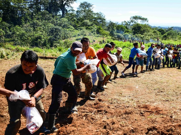 November 25, 2020, Chisec, Guatemala: Guatemalans villagers isolated by the high flood waters from Hurricane Iota unload humanitarian aid delivered by the U.S. Army Joint Task Force Bravo November 25, ...