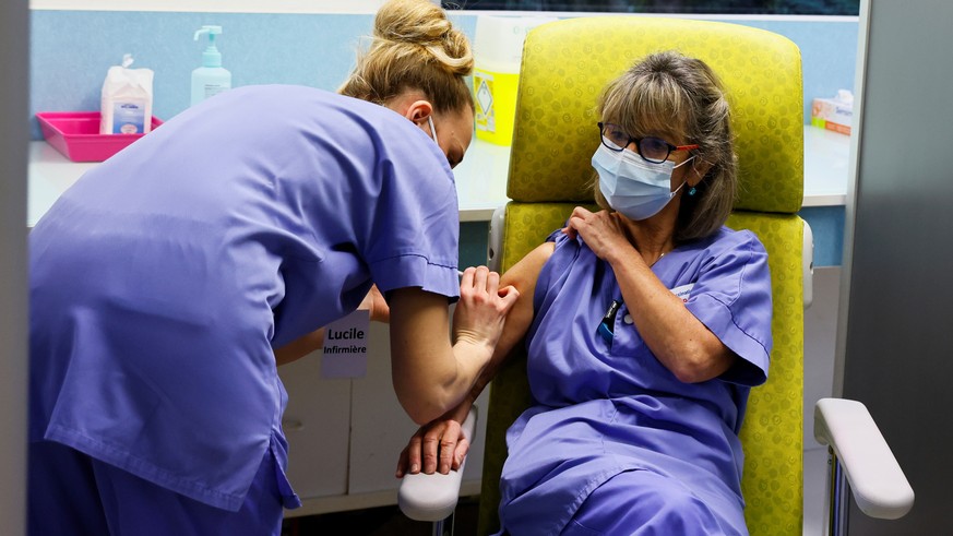 epa08996289 A member of the medical staff vaccinates a colleague with a dose of the AstraZeneca-Oxford Covid-19 vaccine at the South Ile-de-France Hospital Group (Groupe Hospitalier Sud Ile-de-France) ...
