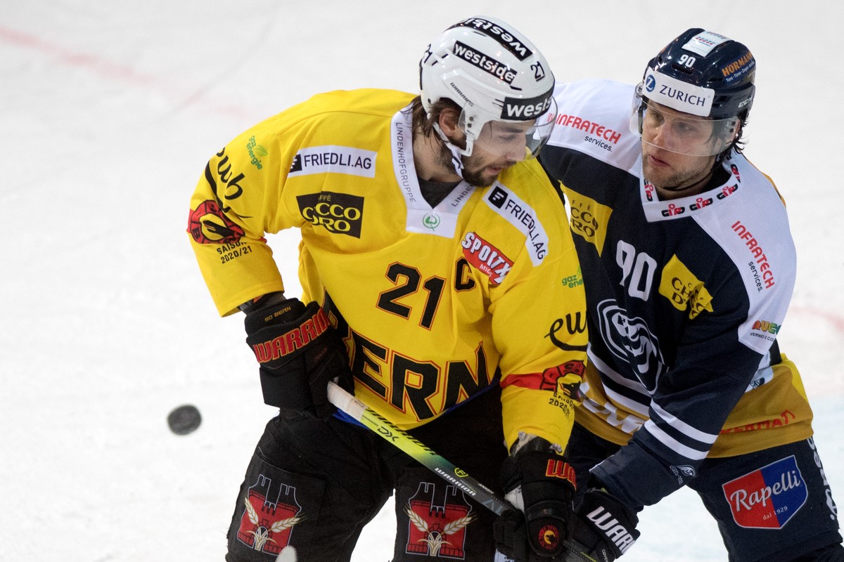 Ambri's player Jannik Fischer, right, fights for the puck with Bern's player Simon Moser, during the preliminary round game of National League A (NLA) Swiss Championship 2020/21 between HC A ...