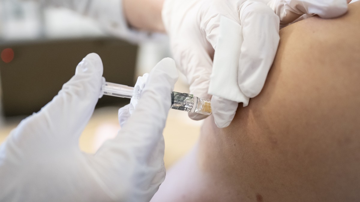Eine Apothekerin verabreicht einem Mann den Impfstoff Fluarix Tetra 2022-2023 gegen die saisonale Grippe, am Freitag, 30. Dezember 2022 in der Kirchenfeld Apotheke in Bern. (KEYSTONE/Anthony Anex)