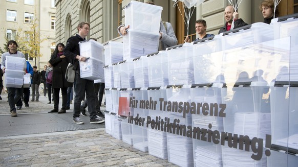 Personen laufen mit den Boxen, die Unterschriften enthalten, in Richtung Bundeshaus-West wahrend der Einreichung der Transparenz-Initiative, am Dienstag, 10. Oktober 2017 in Bern. Das ueberparteiliche ...