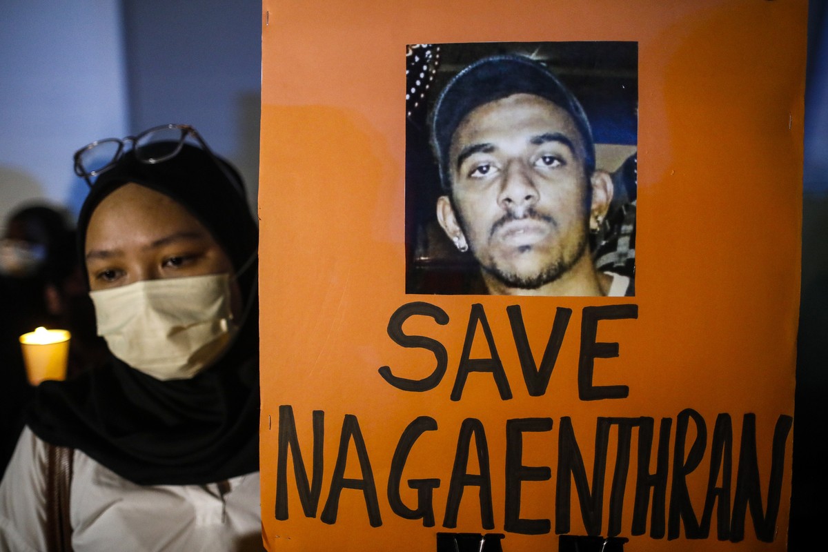 epa09910127 An activist holds a placard and a candle during a candlelight vigil against the death penalty for Malaysian national Nagaenthran K. Dharmalingam, who was convicted of a drug offence 11 yea ...
