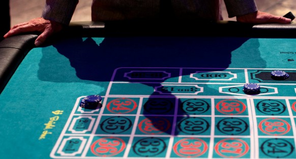 A visitor puts his hands on a mock casino roulette table at an international tourism promotion symposium in Tokyo, Japan September 28, 2013. REUTERS/Yuya Shino/File Photo