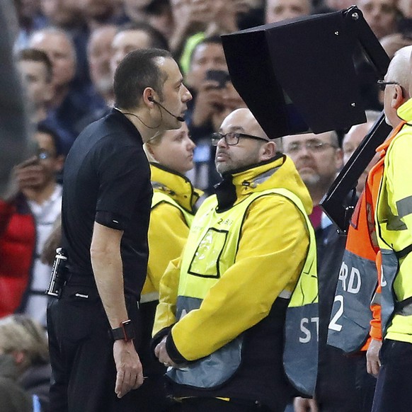 Referee Cuneyt Cakir consults VAR before awarding Tottenham Hotspur their third goal scored by Fernando Llorente during the Champions League quarterfinal second leg soccer match at the Etihad Stadium, ...