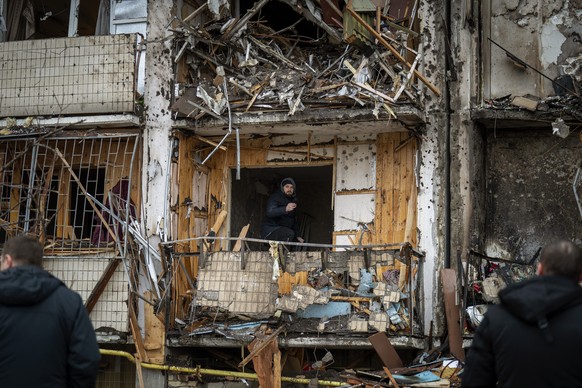 A man inspects the damage at a building following a rocket attack on the city of Kyiv, Ukraine, Friday, Feb. 25, 2022. (AP Photo/Emilio Morenatti)