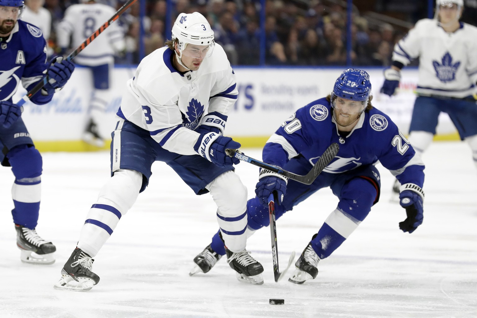 Toronto Maple Leafs defenseman Justin Holl (3) loses the puck to a stick check by Tampa Bay Lightning center Blake Coleman (20) during the first period of an NHL hockey game Tuesday, Feb. 25, 2020, in ...