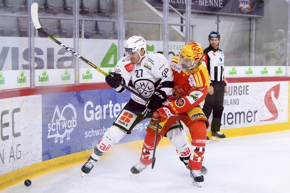 Luganos Alessandro Chiesa, links, und Der Bieler PostFinance Top Scorer Luca Cunti, rechts, kaempfen um den Puck, beim Eishockey Meisterschaftsspiel der National League zwischen dem EHC Biel und den H ...