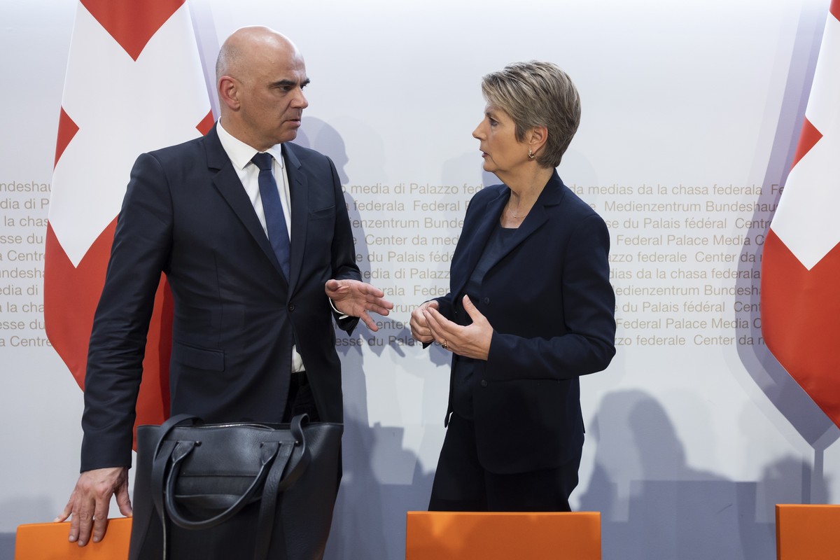 epa10532835 Swiss Federal President Alain Berset (L) and Swiss Finance Minister Karin Keller-Sutter (R) talk at the end of a press conference in Bern, Switzerland, 19 March 2023. The Swiss government  ...